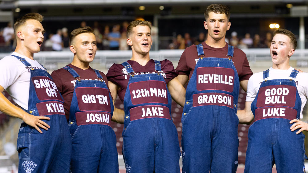 Texas A&M Yell Leaders standing together in a line singing the War Hymn